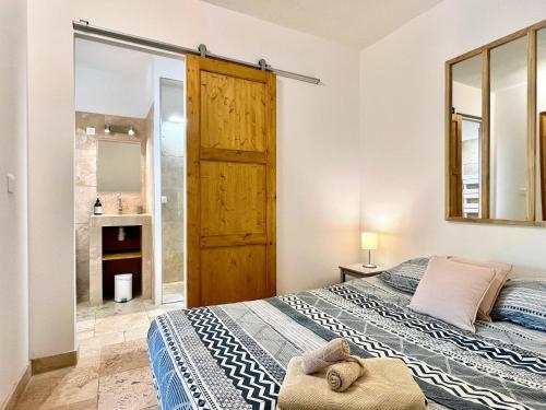 une chambre avec un grand lit et un miroir dans l'établissement Lou Maestoso - Cosy, Campagne, CLIM, 2 personnes, à Lançon-Provence