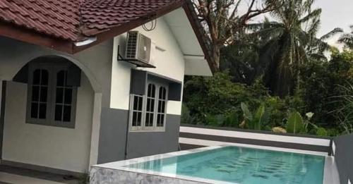 a house with a swimming pool in front of it at Asfara Homestay Jeram in Jeram