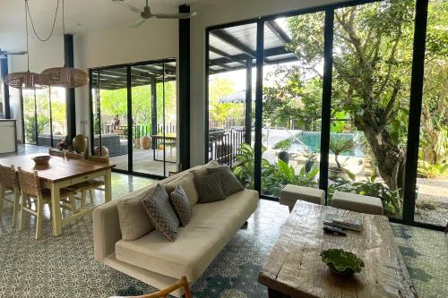 a living room with a couch and a table at Private pool villa with rice field sunset views in Phum Pobos