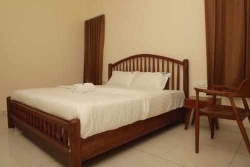 マイソールにあるNilgiri Woodlands Luxury Service Apartmentsのベッドルームにタオル2枚が付いたベッド1台