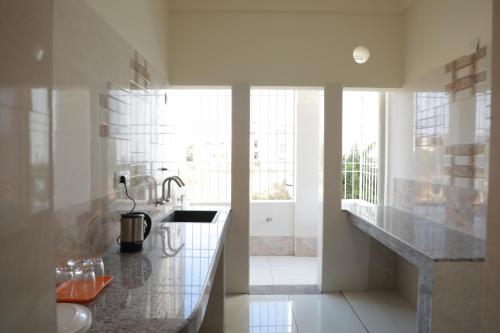 マイソールにあるNilgiri Woodlands Luxury Service Apartmentsのバスルーム(シンク、カウンタートップ付)