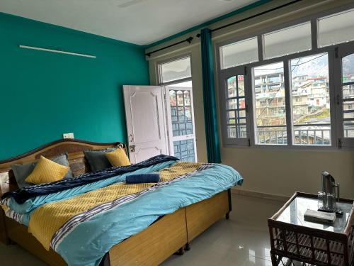 a bedroom with a bed with green walls and windows at Check-in & Chill in Dharamshala