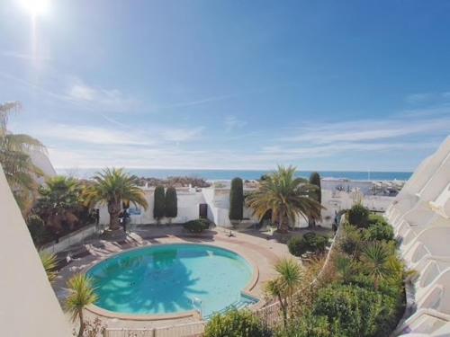 une vue aérienne d'une piscine avec des palmiers dans l'établissement PGH N5-25m de la plage, Vue Mer, Piscine, Parking, à La Grande Motte