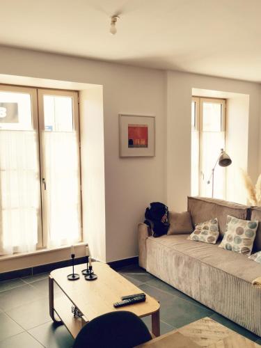 un salon avec un canapé et une table basse dans l'établissement Appartement paisible et spacieux, à Jonzac