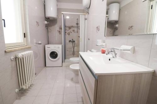 Un baño con lavabo y lavadora. en Casa Ambra a Otranto, en Otranto