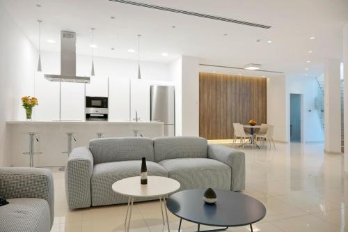 a living room with two couches and a kitchen at Beachfront Luxury Villa Glory in Ayia Napa