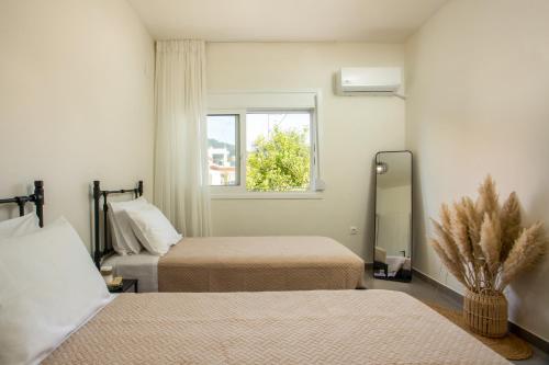 a bedroom with two beds and a window and a mirror at Casa Anastasia in Pastida