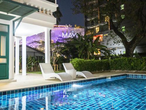 a pool at the mayfair hotel at night at Summer Eternal Pool Villa Nimman in Chiang Mai