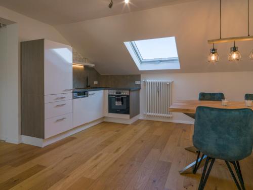 una cucina con tavolo in legno e lucernario di Ferienwohnung Aufhausen - die Sternengucker-Wohnung im 5-Seen-Land a Berg am Starnberger See