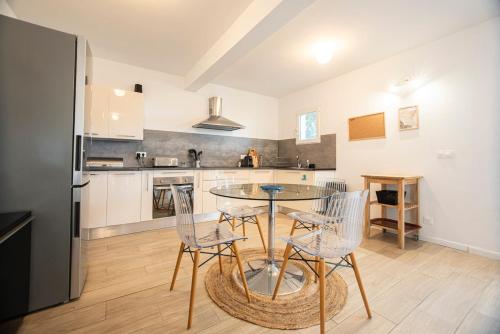 une cuisine avec une table, des chaises et un réfrigérateur dans l'établissement Vista Mare à Cardo - Vue Mer, à Bastia