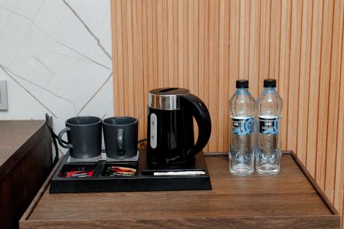 a coffee maker and two bottles of water on a table at INFINITY PLAZA BLOCK 1 in Atyraū