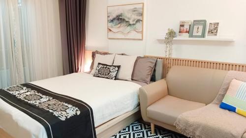 a small bedroom with a bed and a chair at Elio Del Ray Studio walk to BTS in Bangkok