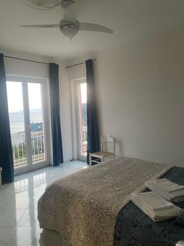 a bedroom with a bed and two large windows at Casa Melograno in Finale Ligure
