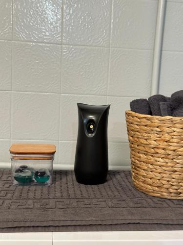 a black vase sitting on a rug next to a basket at Iasonidis Guest House in Dispilio