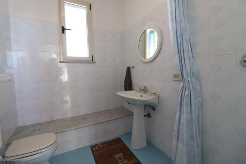 a white bathroom with a toilet and a sink at Casa Nisea Modern Two-Level Home with Sea View in Santa Cesarea Terme in Santa Cesarea Terme