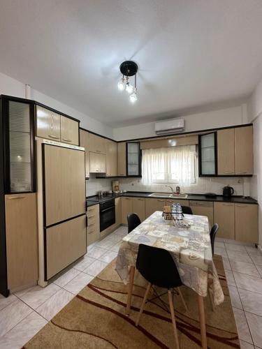a kitchen with a table with chairs and a refrigerator at Iasonidis Guest House in Dispilio