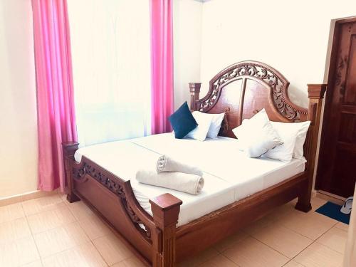a bedroom with a bed with a wooden headboard at 1,2,3 Bedrooms bnb Mtwapa in Mtwapa