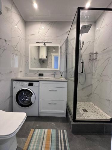 a bathroom with a washing machine and a shower at Delicious Aparts in Odesa