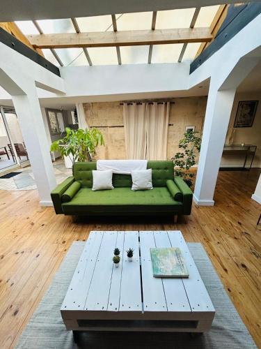 - un salon avec un canapé vert et une table basse dans l'établissement Superbe loft de charme - centre ancien, à Caen