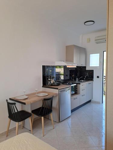a kitchen with a wooden table and a table and chairs at Bratis Apartments in Keri