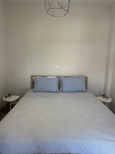 a bed with blue pillows in a bedroom with two tables at Iasonidis Guest House in Dispilio