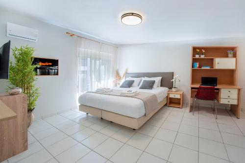 a bedroom with a bed and a desk with a laptop at Sunwaves City Center Apartment in Rhodes Town