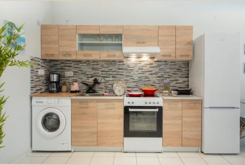 a kitchen with a stove and a washing machine at Sunwaves City Center Apartment in Rhodes Town