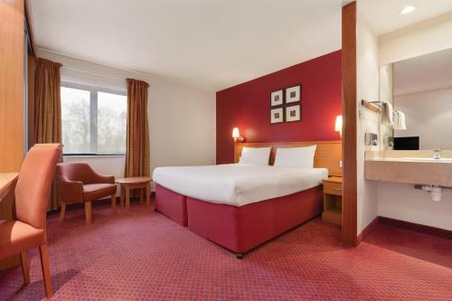a hotel room with a bed and a sink at Days Inn Stevenage North in Baldock