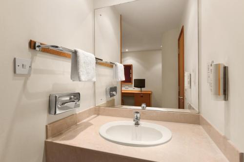 a bathroom with a sink and a mirror at Days Inn Stevenage North in Baldock