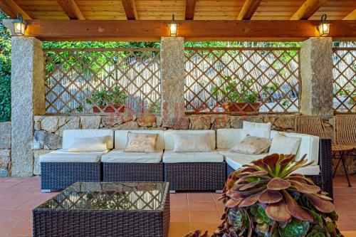 a patio with a white couch on a patio at Domus de pedra in Marina di Portisco