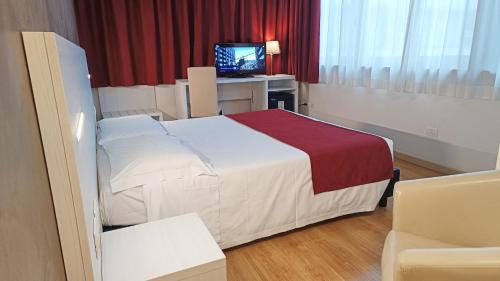 a hotel room with a bed and a television at Hotel President in Prato
