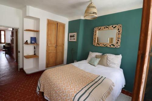Un dormitorio con una cama con una pared azul. en Joli appartement sur le port proche des plages !, en La Ciotat