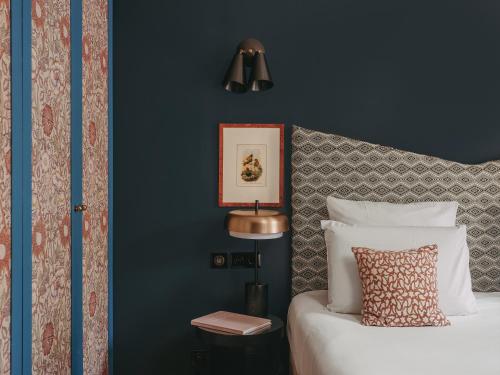 a bedroom with a bed and a blue wall at Maison Malesherbes in Paris