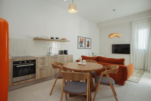 a kitchen and living room with a table and a couch at LIV & CO Suites & Villas in Voroklini