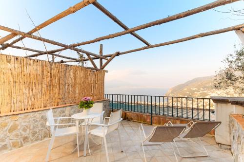 a balcony with a table and chairs and a view of the ocean at Villa Rosa di Nonna Rosa in Vico Equense