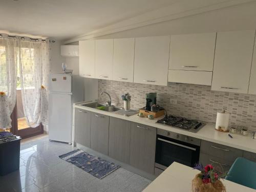 una cucina con mobili bianchi e un lavello di Gine's Tropea Home a Tropea