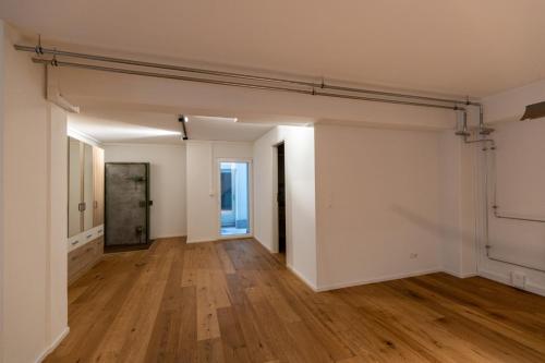an empty room with white walls and wood floors at Ferienoase Granula - Bad Ragaz in Bad Ragaz