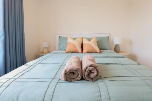 a bedroom with a bed with towels on it at Modern 2-Bed Townhouse Close to City Attractions in Addington