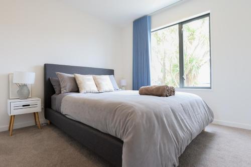 a bedroom with a large bed with a large window at Modern 2-Bed Townhouse Close to City Attractions in Addington
