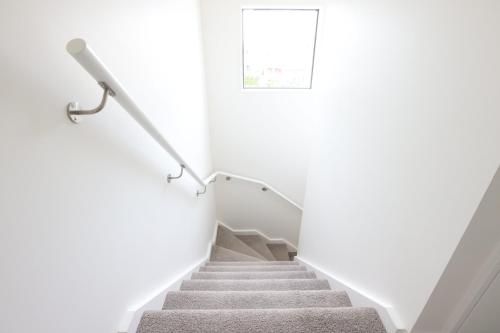 a staircase in a house with white walls at Modern 2-Bed Townhouse Close to City Attractions in Addington