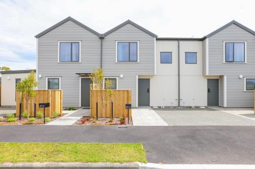 a house with a fence in front of it at Modern 2-Bed Townhouse Close to City Attractions in Addington