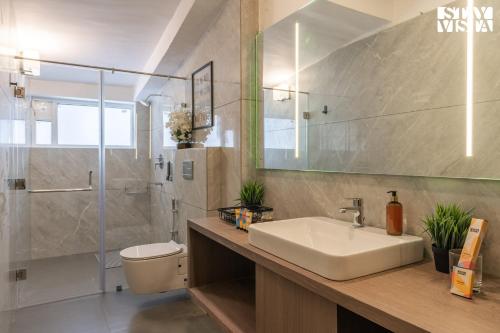 a bathroom with a sink and a shower and a toilet at StayVista at La Casa Oberoi with Lawn & Mountain View in Bhīm Tāl