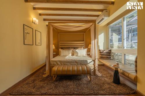 a bedroom with a canopy bed and a window at StayVista at La Casa Oberoi with Lawn & Mountain View in Bhīm Tāl