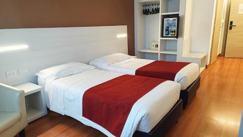 a hotel room with two beds and a television at Hotel President in Prato