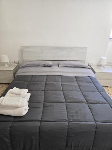 a bedroom with a large bed with towels on it at Mak house in Palermo