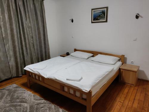 a bedroom with a large bed with white sheets at Luni in Travnik