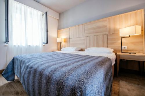 a bedroom with a large bed with a blue blanket at Zaton Holiday Resort in Nin
