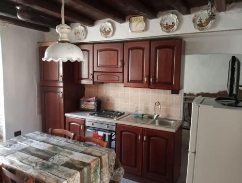 a kitchen with wooden cabinets and a table with a sink at La Persellina House in Sant' Agata fossili
