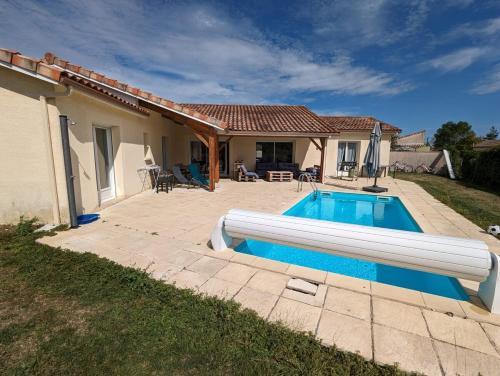 une piscine devant une maison dans l'établissement Villa Pourpre-Piscine Chauffée-Climatisation-Jardin, à Bouniagues
