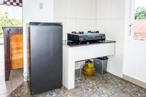 a kitchen with a stove and a sink in it at Sophies Apartment Tuktuk in Tuk Tuk